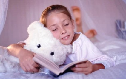 Child reading to stuffed animal