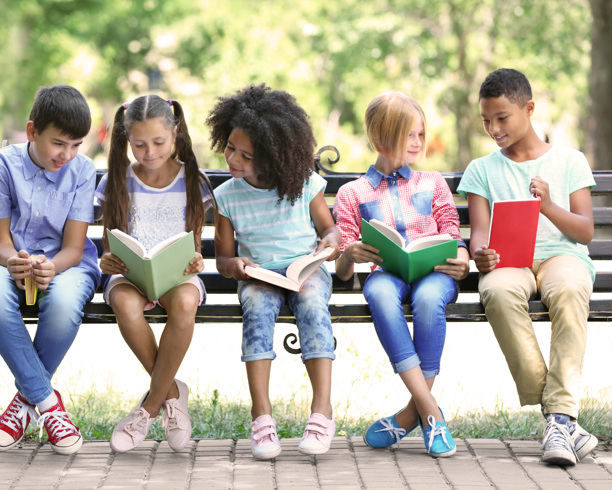 Five kids sit on bench with open books.