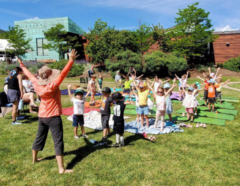 Images of an adult yoga instructor and a class of children outdoors.