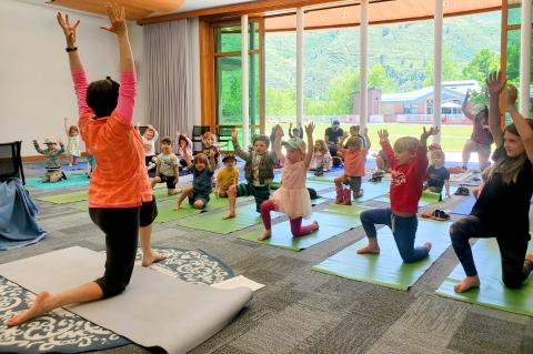 Teacher in front of yoga class in background
