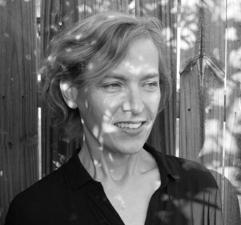 Black and white headshot of a white woman (Julie Carr) with short hair smiling and looking to the side