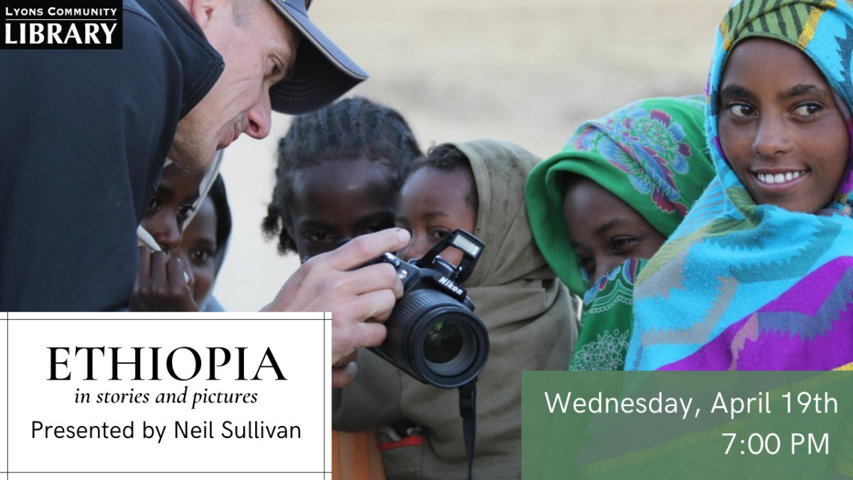 A photo of Neil Sullivan showing a camera to a group of Ethiopian children